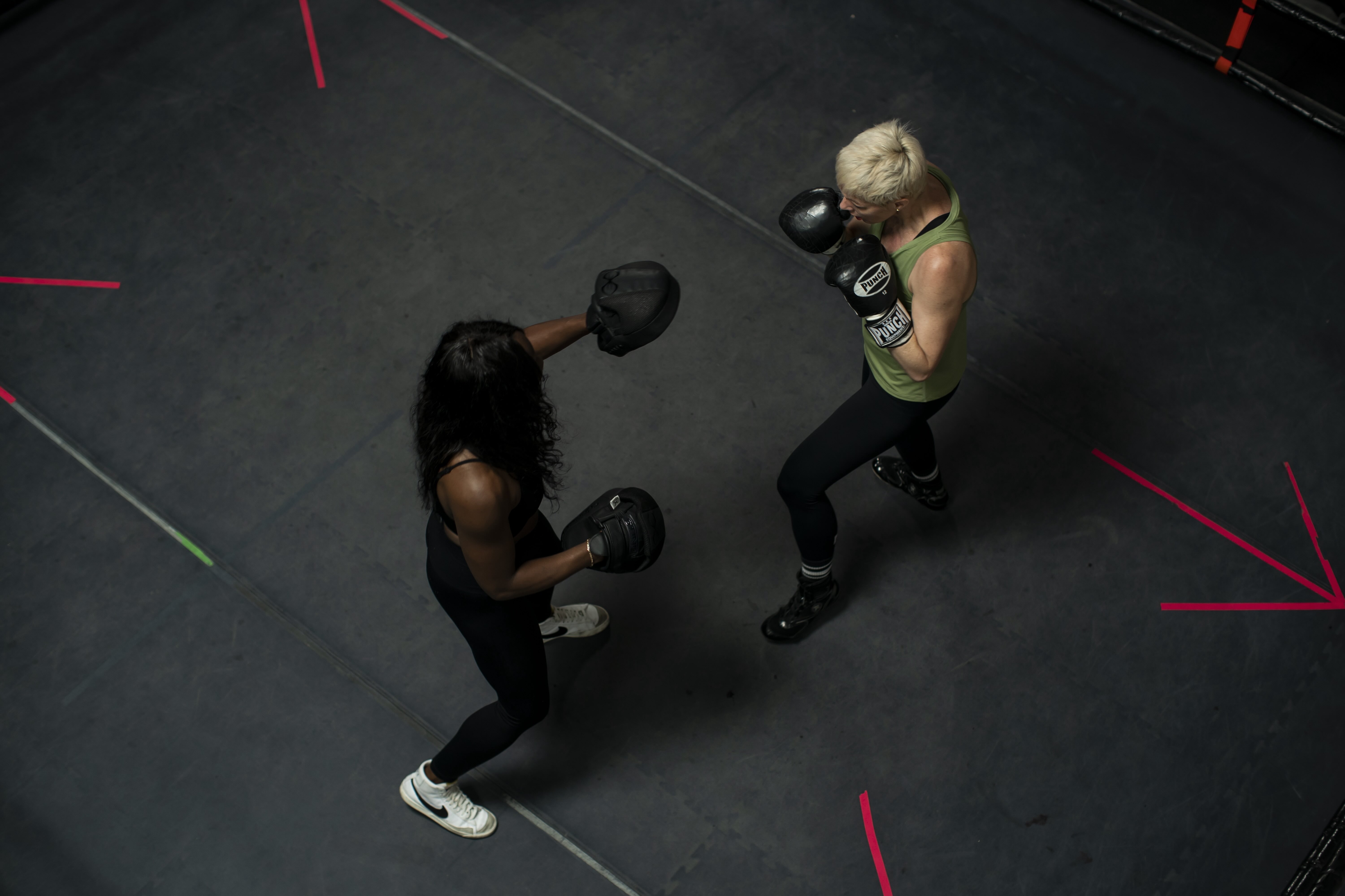 Two people stand in a boxing ring