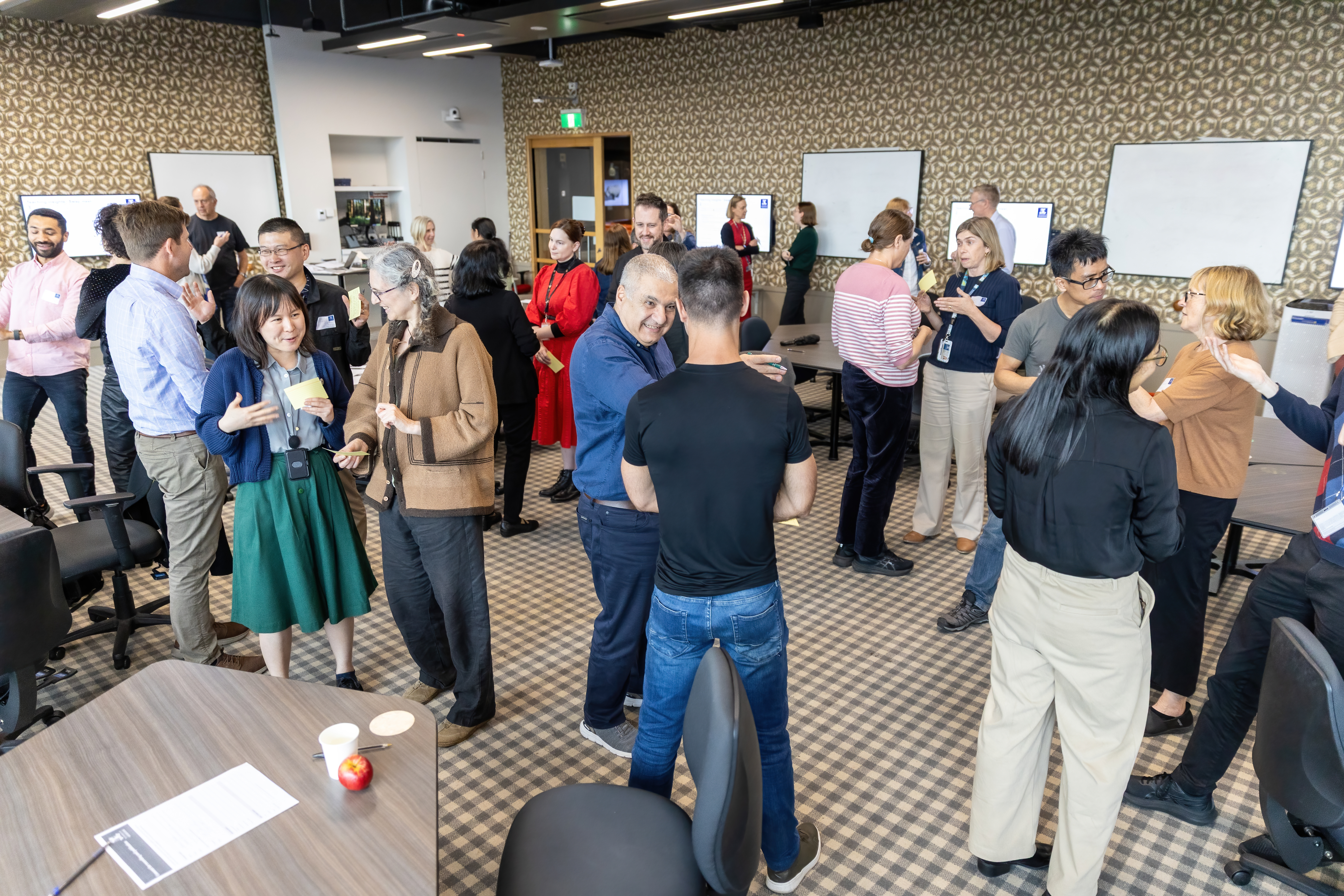 image of many people standing around talking to each other in a room