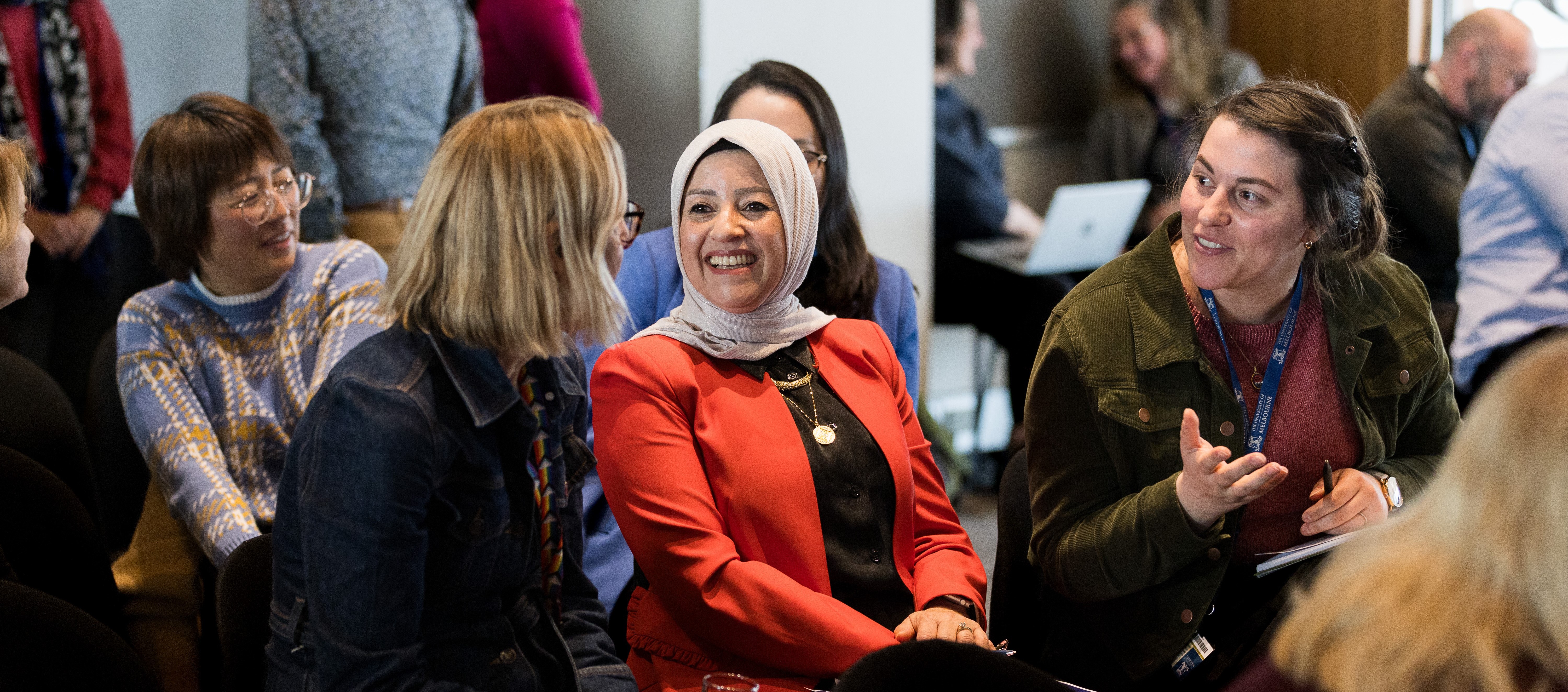 Image of three people sitting at a conference talking to each other