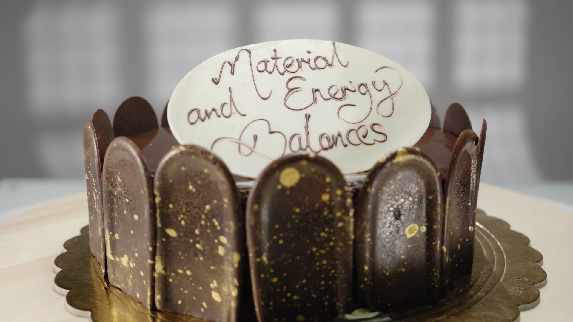 Image of chocolate cake with icing that reads 'Material and Energy Balances'