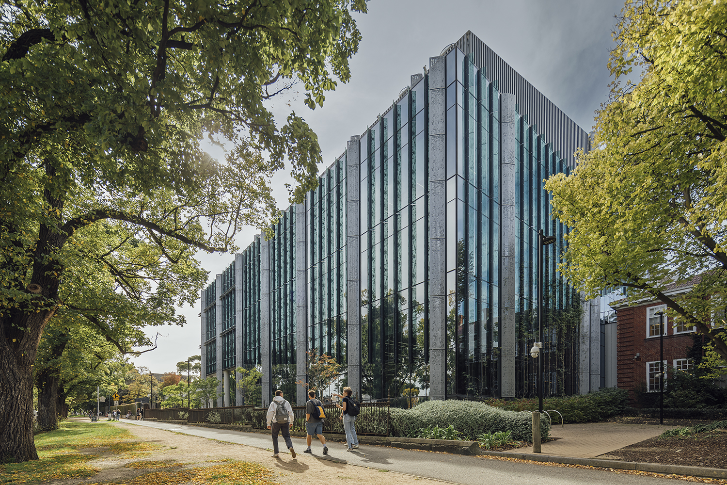 Students walking past a modern university building 