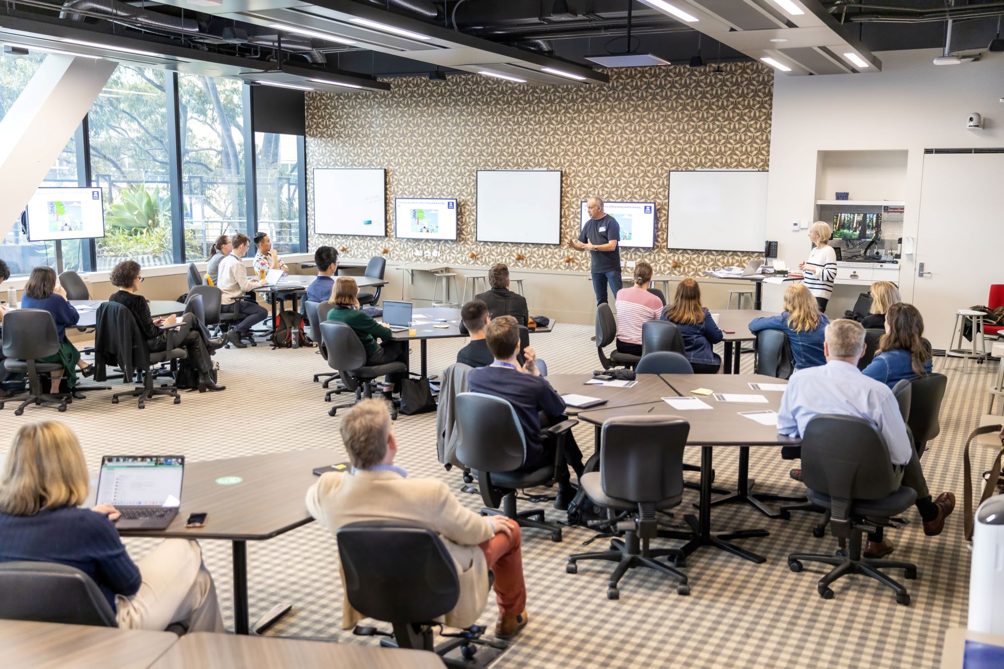image of people sitting in a classroom looking toward the two presenters at the front of the classroom