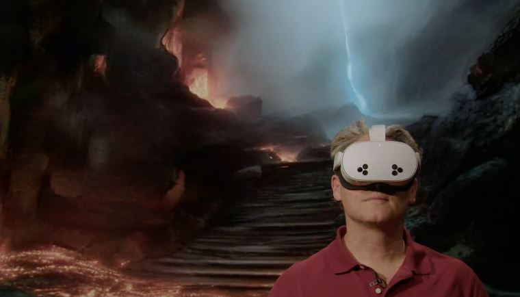 Image of Mitch in a VR headset with the background of steps with fire around them and a blue shining light of lightning above 