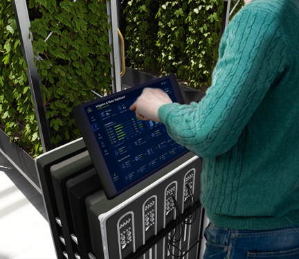 A person tapping on a dashboard screen, there are plants in the background
