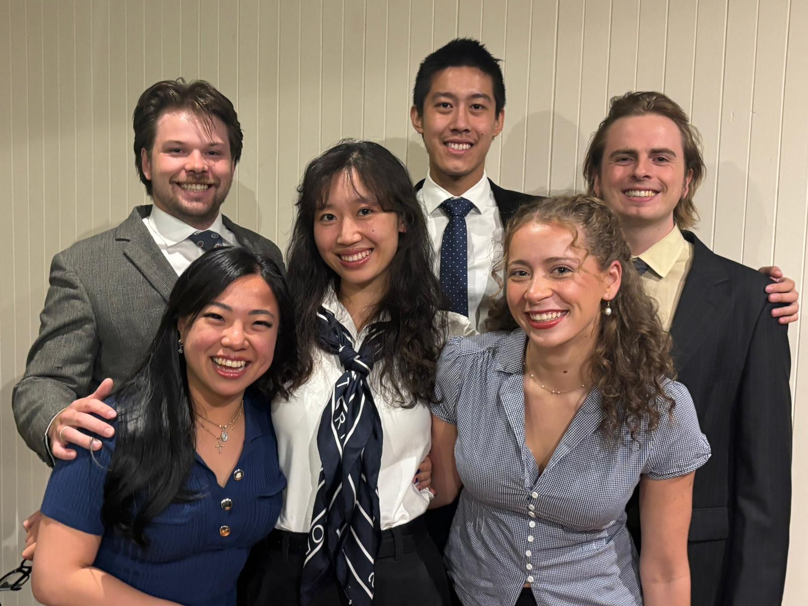 Image of the six students participating in the competition, they are standing in a group smiling 